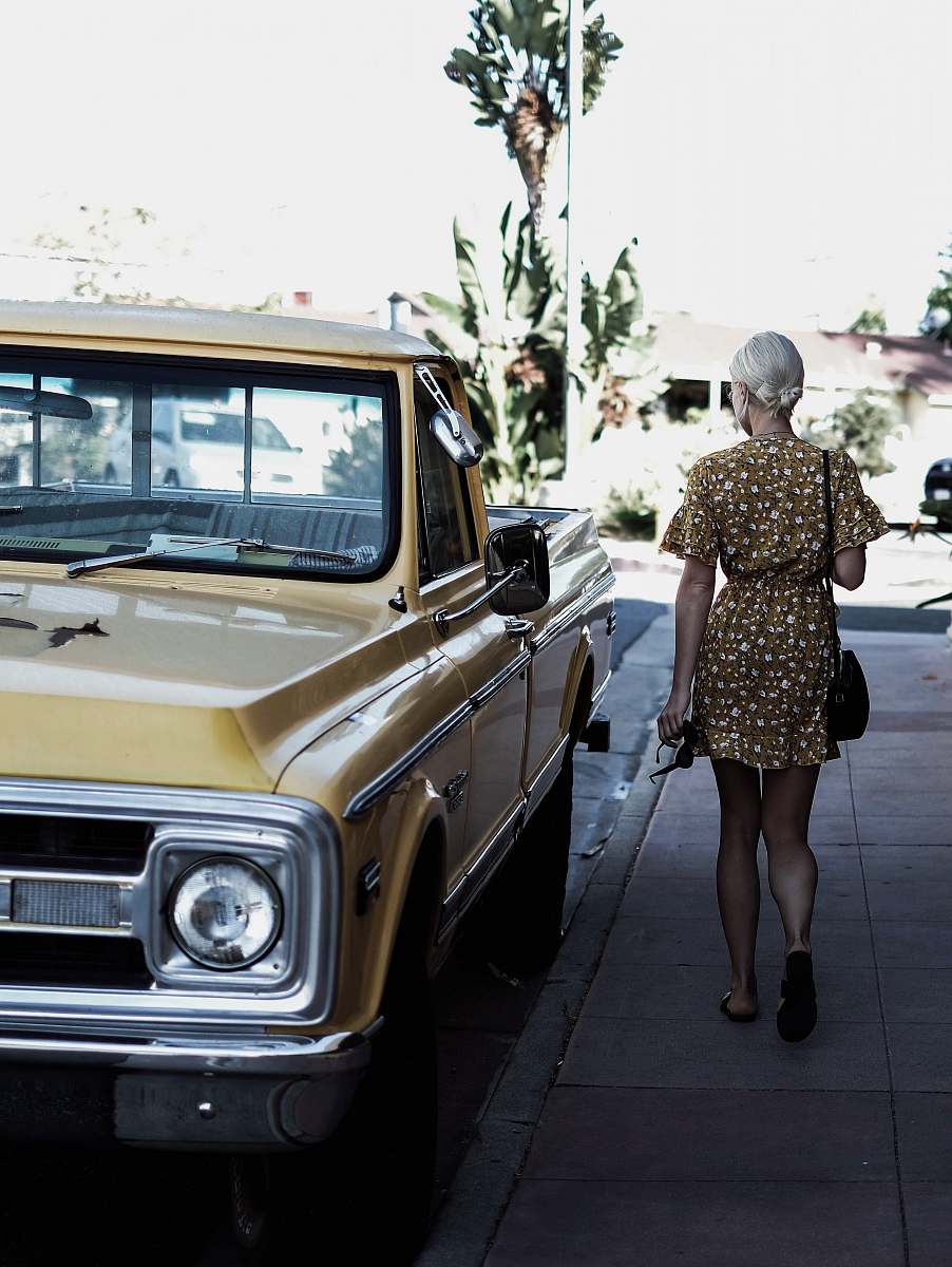 san clemente woman walking beside a car truck